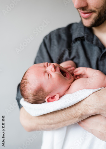 Father enjoys a tender moment with yawning baby