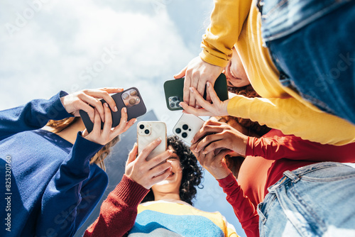 Young girls enjoying time together with cellphones photo