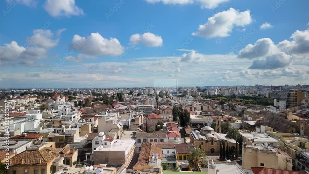 A rooftop view of Nicosia, Cyprus, with various buildings, including high-rises and residential areas. Blue sky with fluffy clouds, highlighting the city's architectural diversity A rooftop view of Nicosia, Cyprus, with various buildings, including high-rises and residential areas. Blue sky with fluffy clouds, highlighting the city's architectural diversity