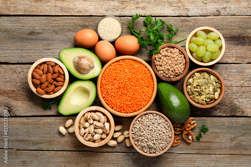 Different products high in natural fats on wooden table, flat lay