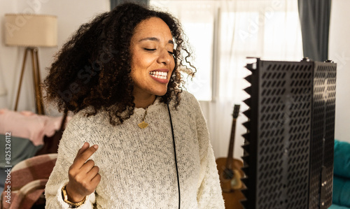 Joyful woman sings into microphone photo