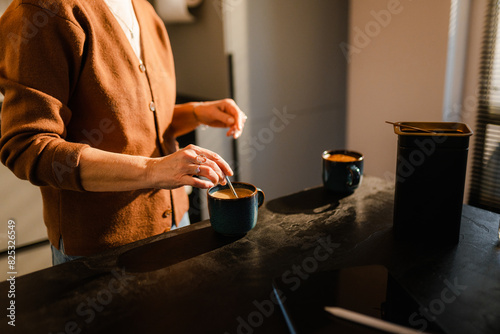 A woman makes coffee at home photo