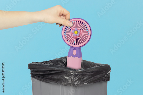 throw the fan into the trash, outstretched hand with fan in front of the trash can