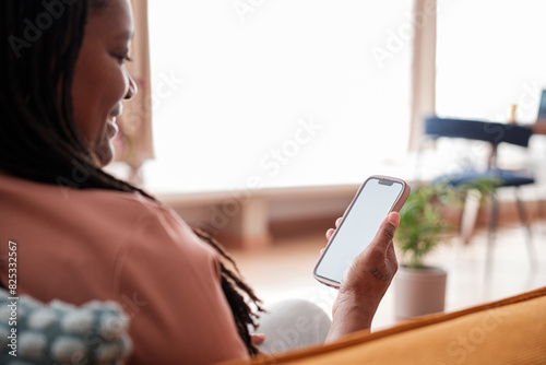 Woman using smartphone at home photo