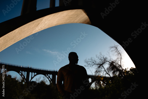 Silhouette of Gay Man posed under bridge photo