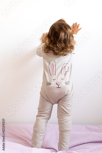 A toddler with a bunny pyjama photo