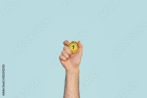 Person holding first prize gold medal. Success, competition, winner. photo