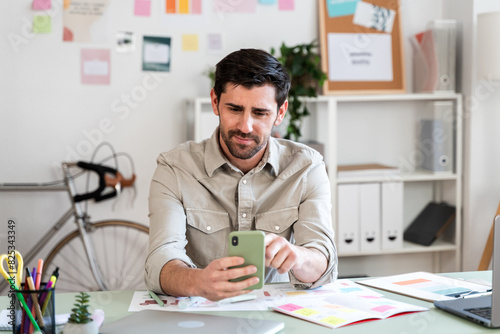 Man Browsing Smartphone in Office photo