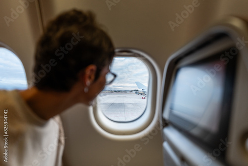 Woman looking out of the airplane window. photo