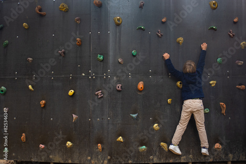Young boy climbs an artificial rock photo
