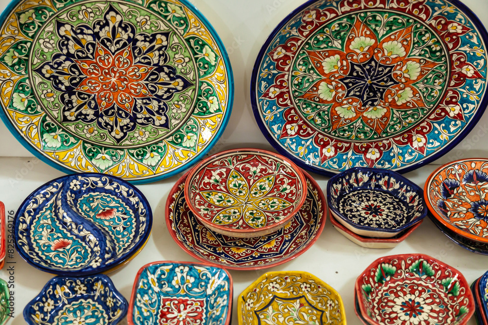 Fototapeta premium Traditional ceramics of Central Asia. Ancient traditional Uzbek ceramic dishes with national ornaments. Colorful handmade ceramics from Uzbekistan.
