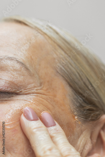 Mature Woman Applying Face Serum photo
