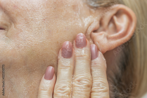 Mature Woman Applying Face Serum
