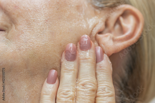 Mature Woman Applying Face Serum photo