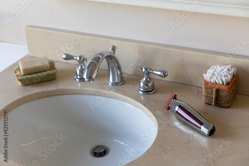 Vertical image Electric shaver still life in bathroom sink 