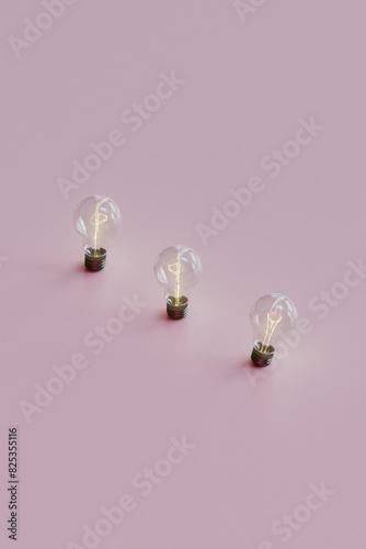 Trio of Light Bulbs on Soft Pink Surface photo