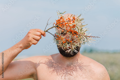 Man with Sea Buckthorn Branch on Face