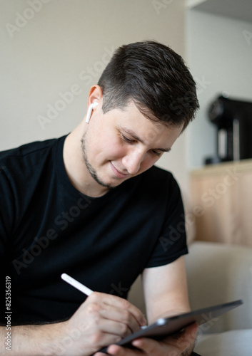 Man using tablet with pen at home environment photo