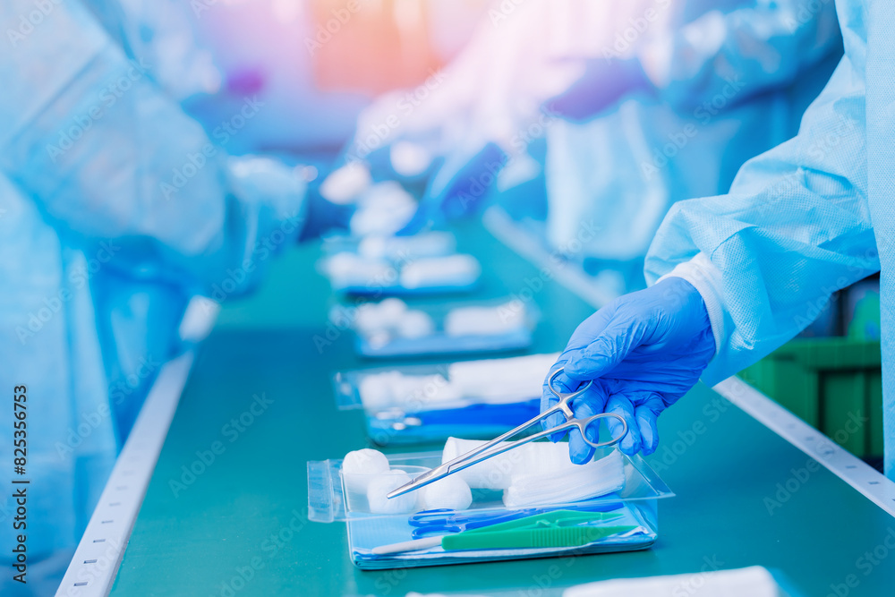 Surgery kit on conveyor line, Precise assembly of medical tools, including scissors, laid out in clear, organized manner by healthcare workers