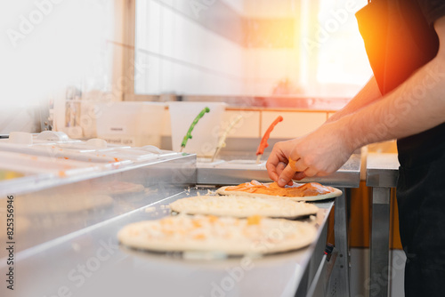Pizzamaker stretches dough, worker preparing fresh food pizza, top view. Business pizzeria concept.