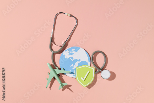 Stethoscope on passport with medical insurance shield symbol photo