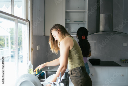 couple cleaning up the kitchen after eating photo