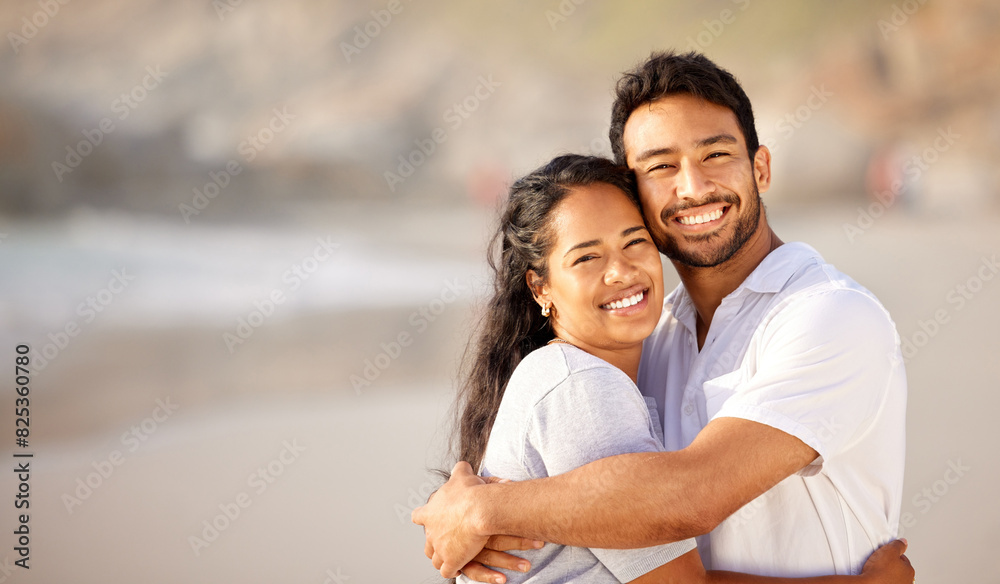 Obraz premium Portrait, smile and couple hug at beach on holiday, vacation or travel together outdoor in summer. Face, happy man and woman embrace at ocean for care, love and support for connection on date at sea