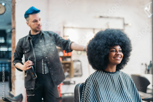 hairdresser combing his client's afro hair photo