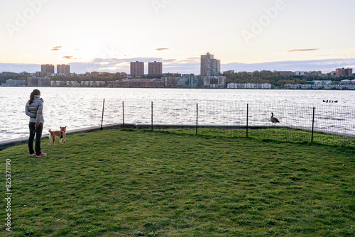 A women look at the Hudson River from the wooden walkway at Hudson River park, New York