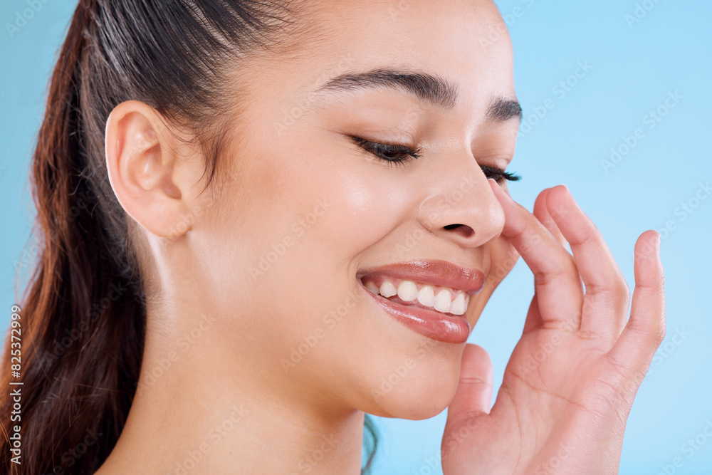 Studio, relax and hand of happy woman with skincare, cosmetics or natural makeup for healthy glow. Beauty, dermatology and face of girl thinking with confidence, wellness and smile on blue background