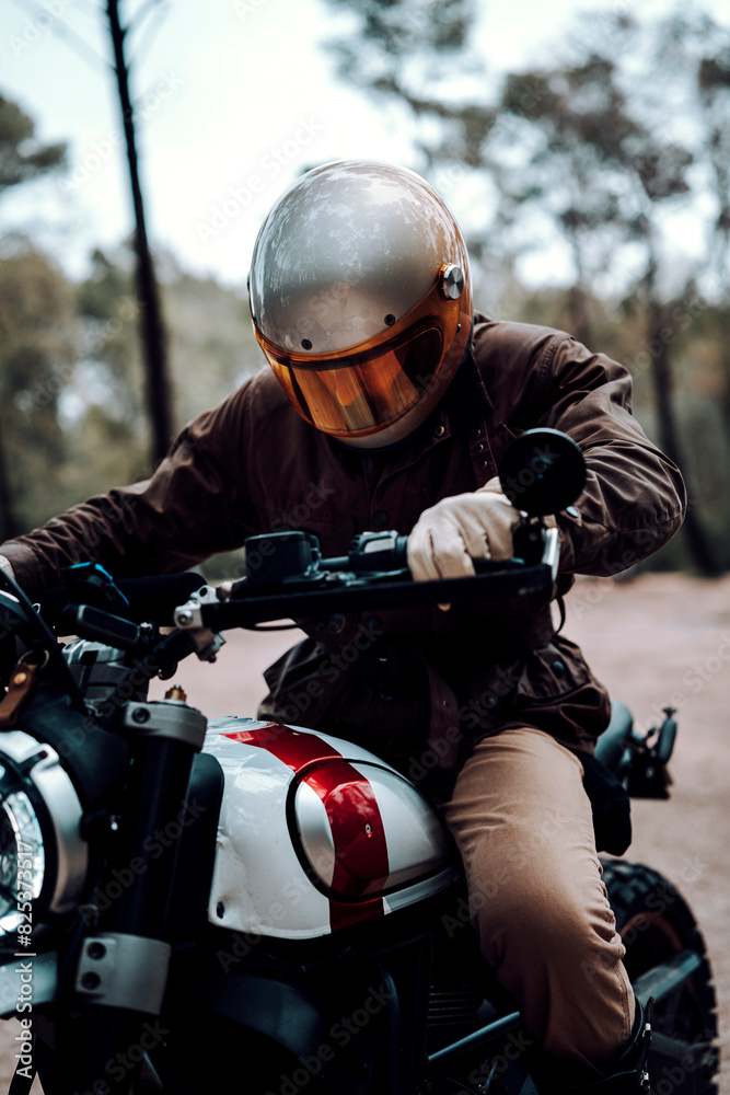Vertical shot of a man seated on a motorcycle, gripping the handlebars Vertical shot of a man seated on a motorcycle, gripping the handlebars