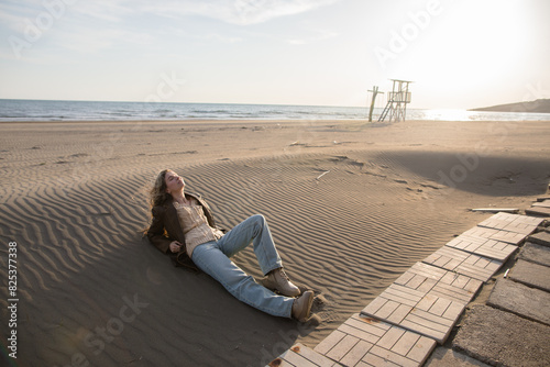 Young woman under the warm spring sun on the beach photo