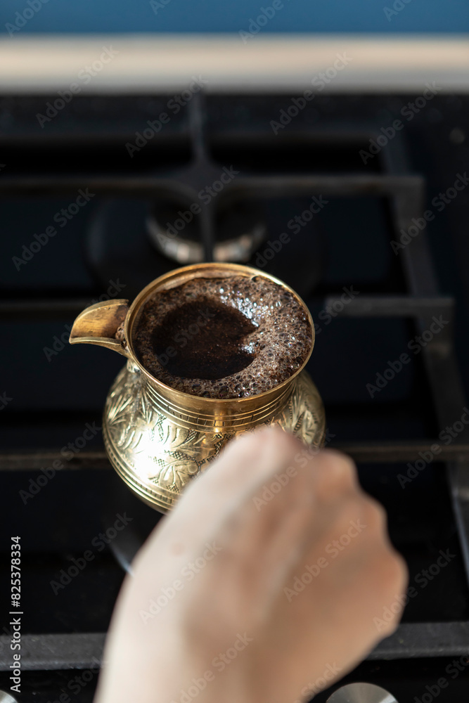 Close up shot of preparation of turkish coffee using copper cezve on the gas stove Close up shot of preparation of turkish coffee using copper cezve on the gas stove