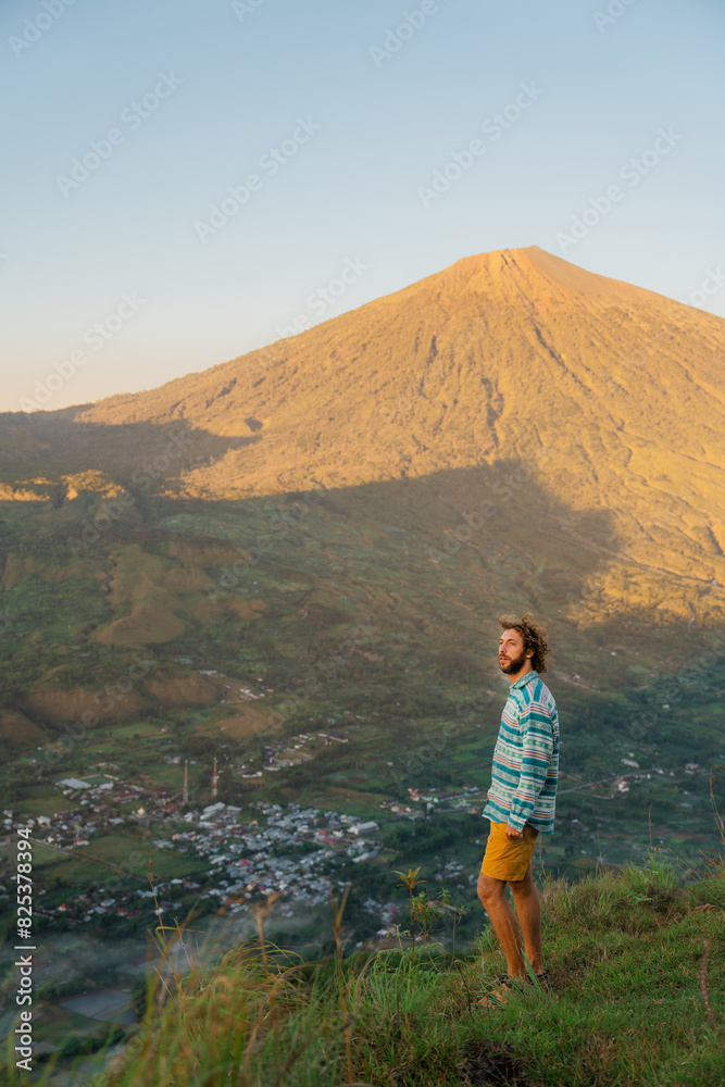 Man looking at scenic volcanic landscape on Lombok during the hike 