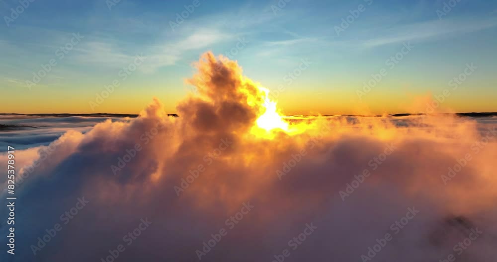 Drone timelapse of dense clouds moving in colorful sky and shiny sun in the background at sunset