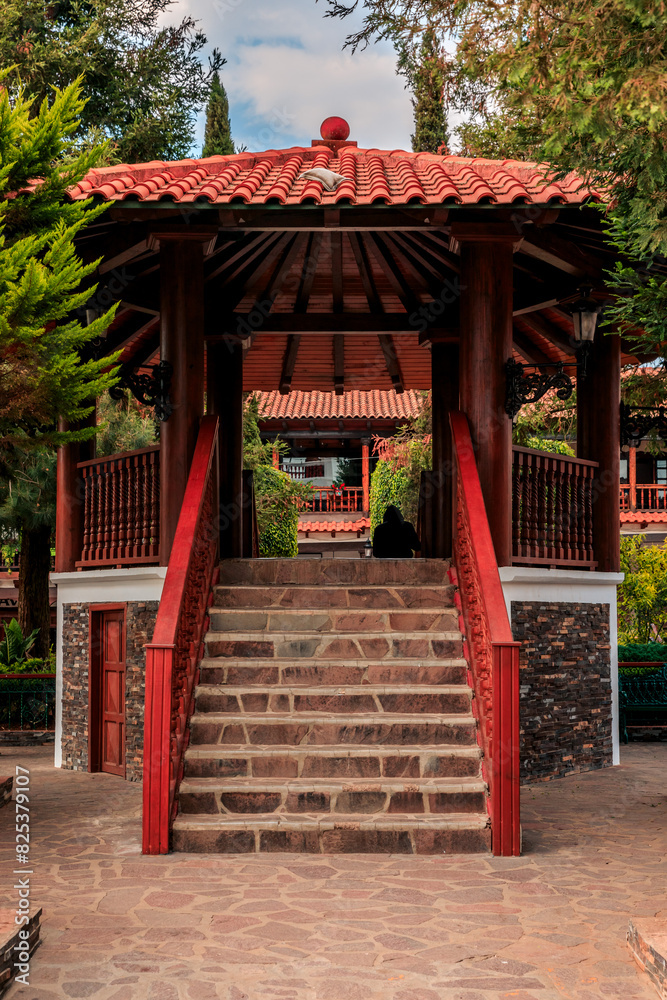 the red wooden structure in the park is very colorful with red and white accents the red wooden structure in the park is very colorful with red and white accents