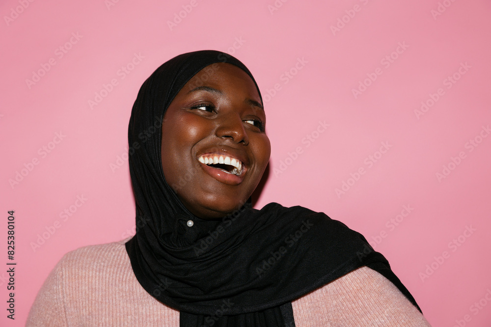 Cheerful woman in hijab looking away Cheerful woman in hijab looking away