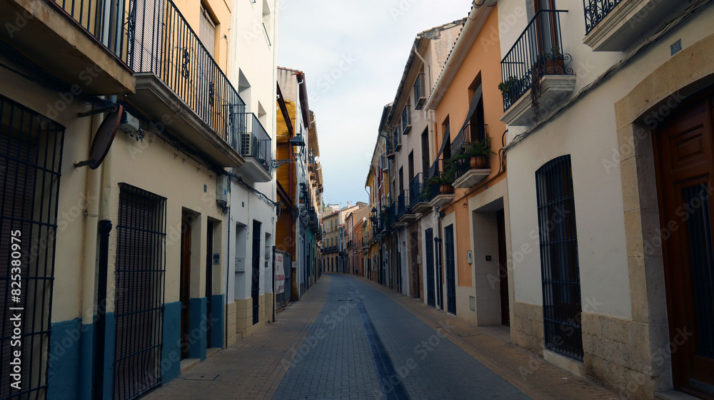 Obraz premium Street in the old Spanish city of Denia, with colorful ancient houses, stone pavement 