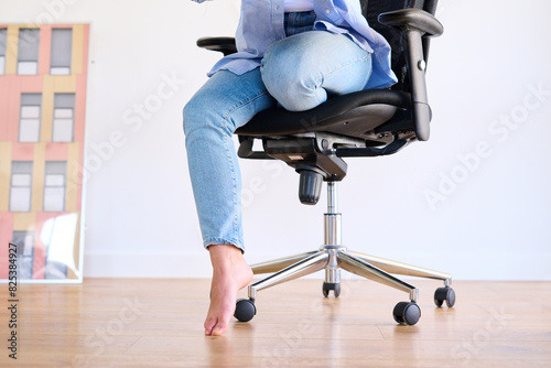 Barefoot Person on Office Chair photo