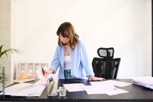 Businesswoman Reviewing Financial Reports at Her Desk