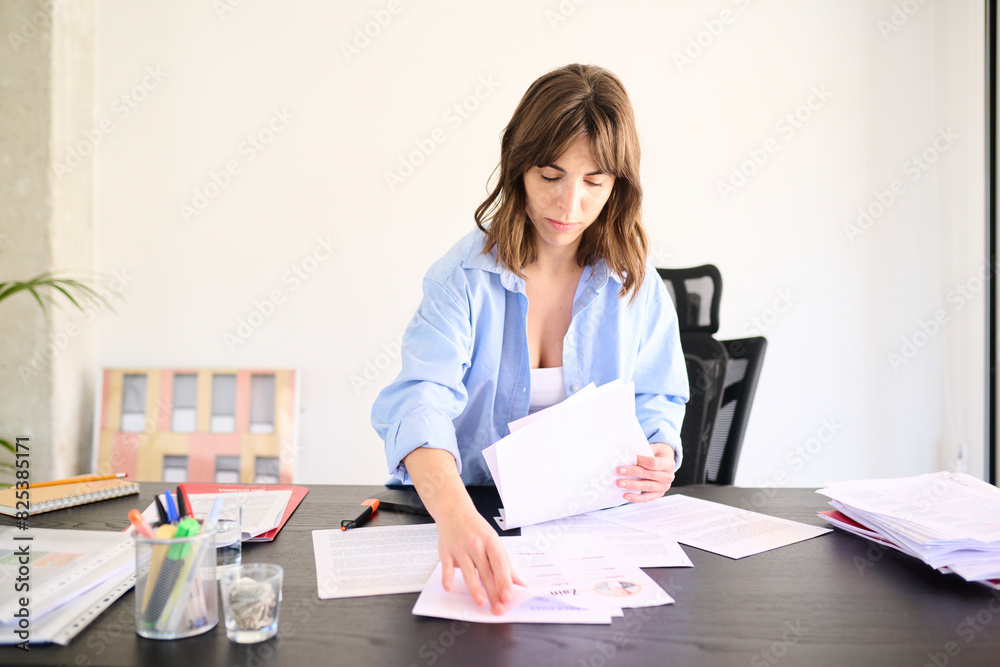 Businesswoman Sorting Through Papers at Her Desk Businesswoman Sorting Through Papers at Her Desk