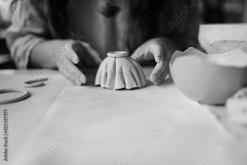 young woman makes ceramic dishes in the workshop photo