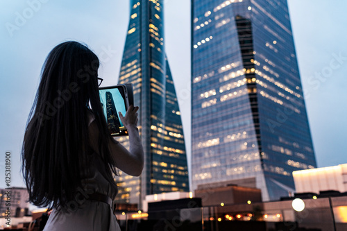 Woman urban explorer photographing architecture with digital tablet photo