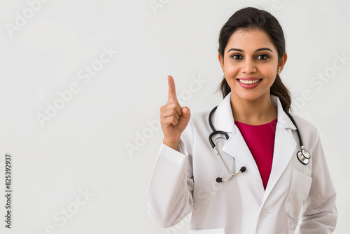 A woman in a white lab coat is pointing to the sky. Indian doctor  nurse and medical student. College and university
