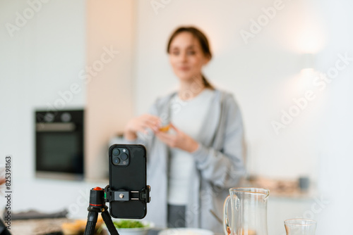A woman shoots a blog on her phone photo