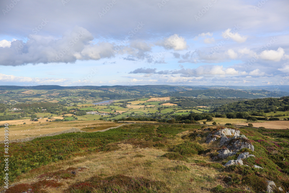 Scenic landscape with rolling hills, green grass, and fluffy clouds in the sky. Wales Scenic landscape with rolling hills, green grass, and fluffy clouds in the sky. Wales