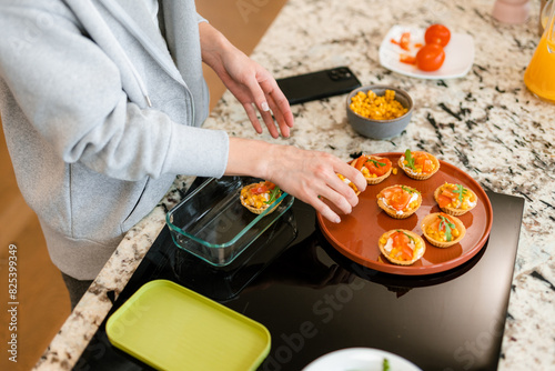 A woman puts ready-made food in a container photo