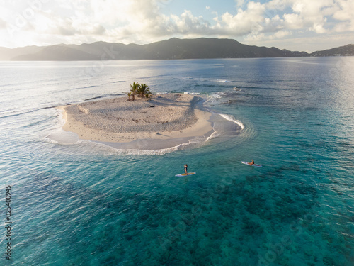 Woman Paddling Around Deserted Caribbean Island on SUP Boards photo