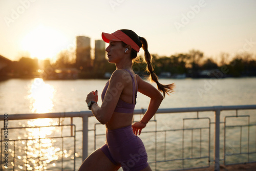 Portrait of a fit woman running on the river quay photo