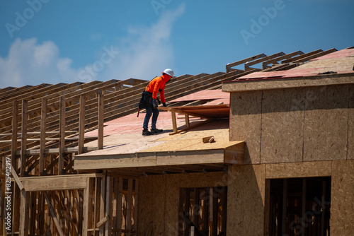 Roofing construction. Roofer roofing on roof structure. Roofing Wooden House Frame. Worker roofer builder working on roof at construction site. Construction builders Roofing.